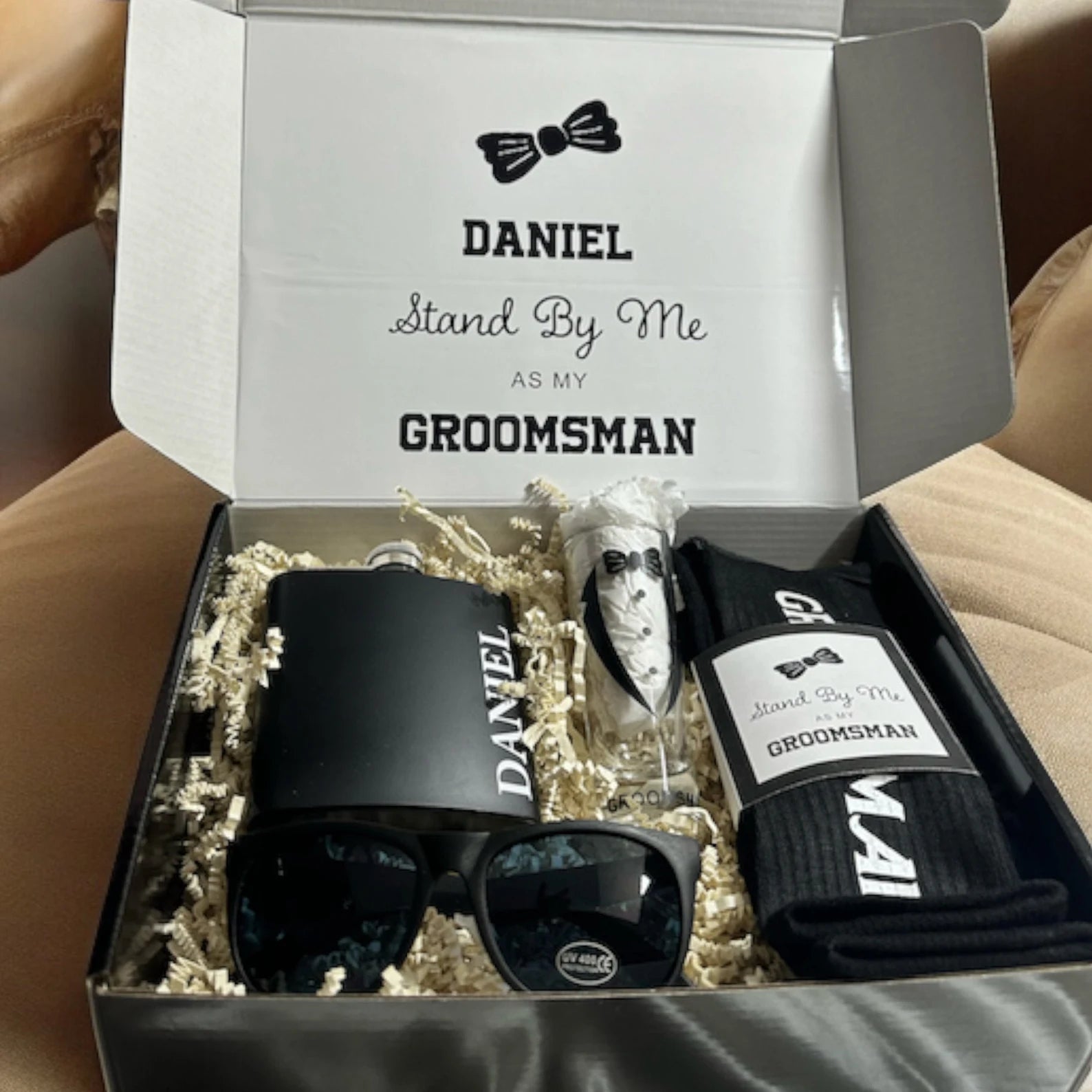 Gift set with socks, sunglasses, and a bow tie in a box with 'Stand By Me' text.