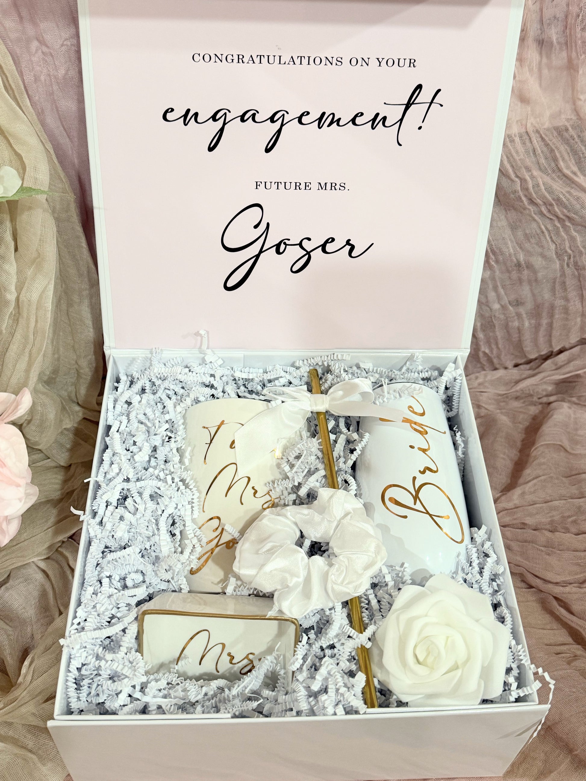 Future Mrs. engagement gift box featuring a white magnetic gift box that includes a personalized white ceramic mug with gold lettering, a chic porcelain ring dish, a stainless steel champagne flute, a satin hair scrunchie, and bridal shower must-haves, all styled in a luxury white keepsake box with satin bow — the perfect personalized bride-to-be gift for engagements, weddings, or bridal showers.