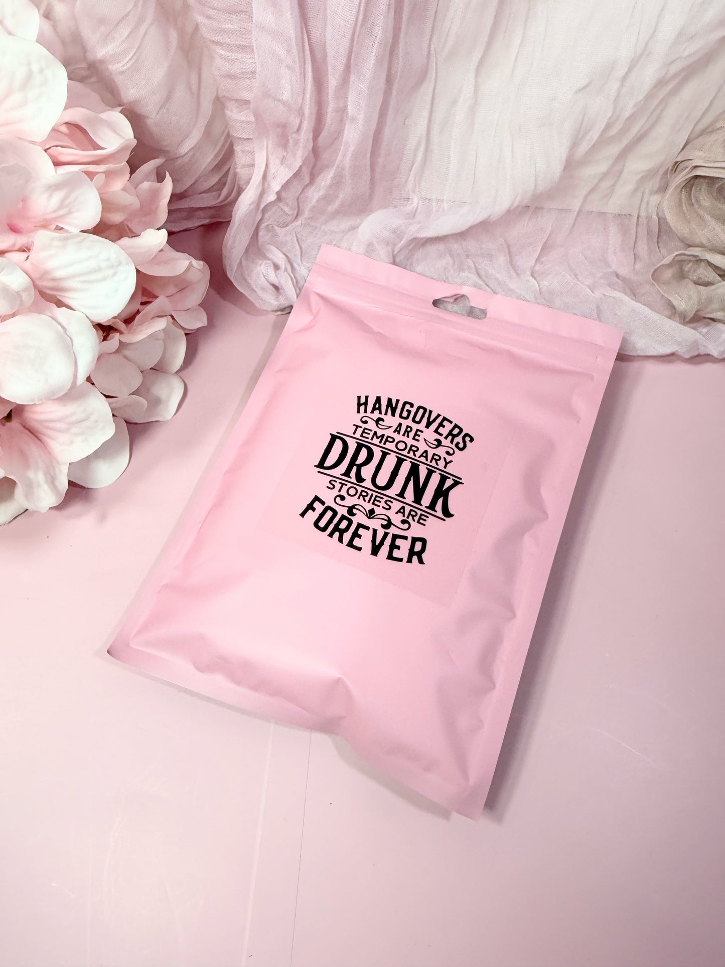 Pink poly pouch with humorous text on a pink background with flowers