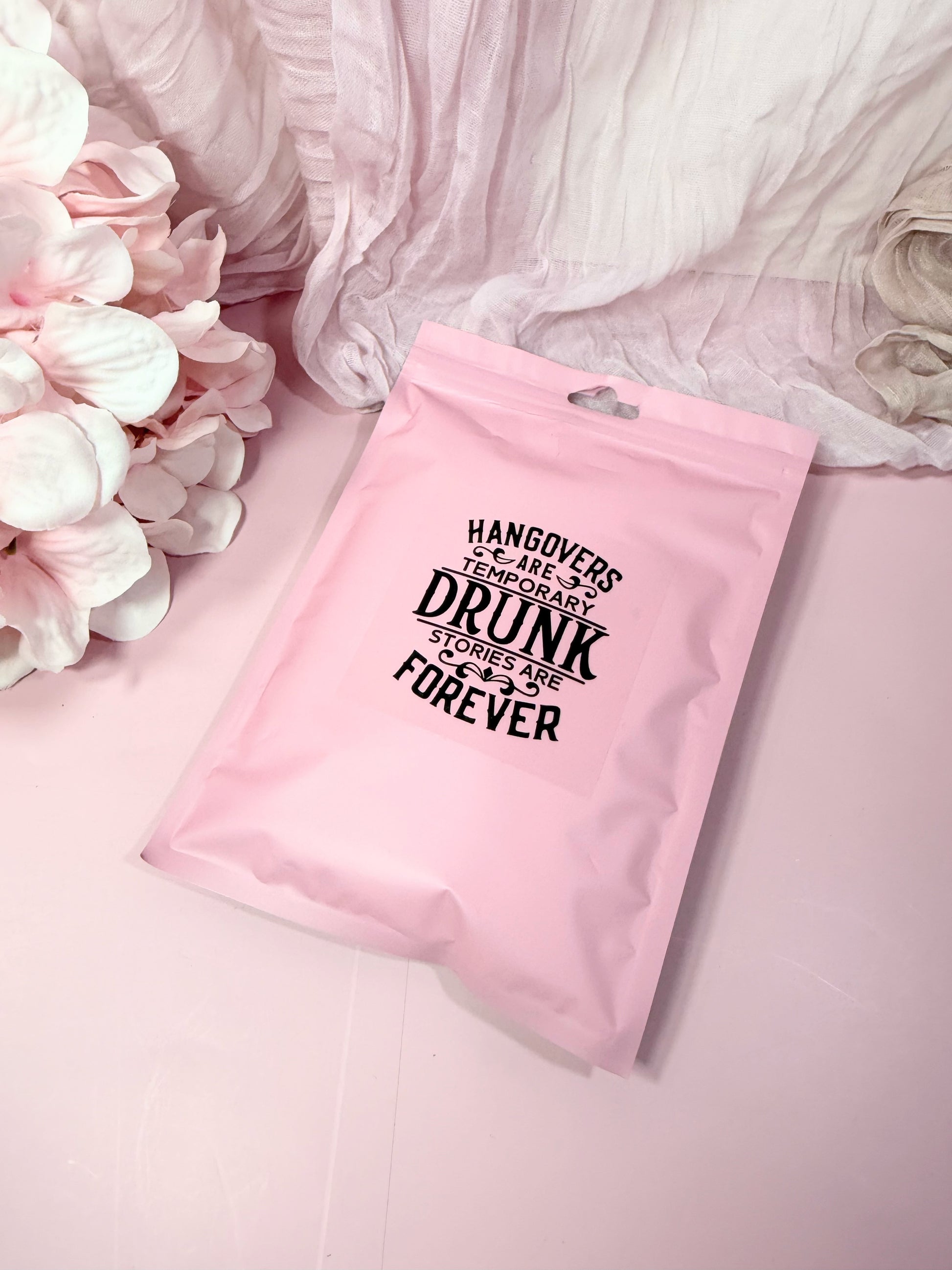 Pink poly pouch with humorous text on a pink background with flowers