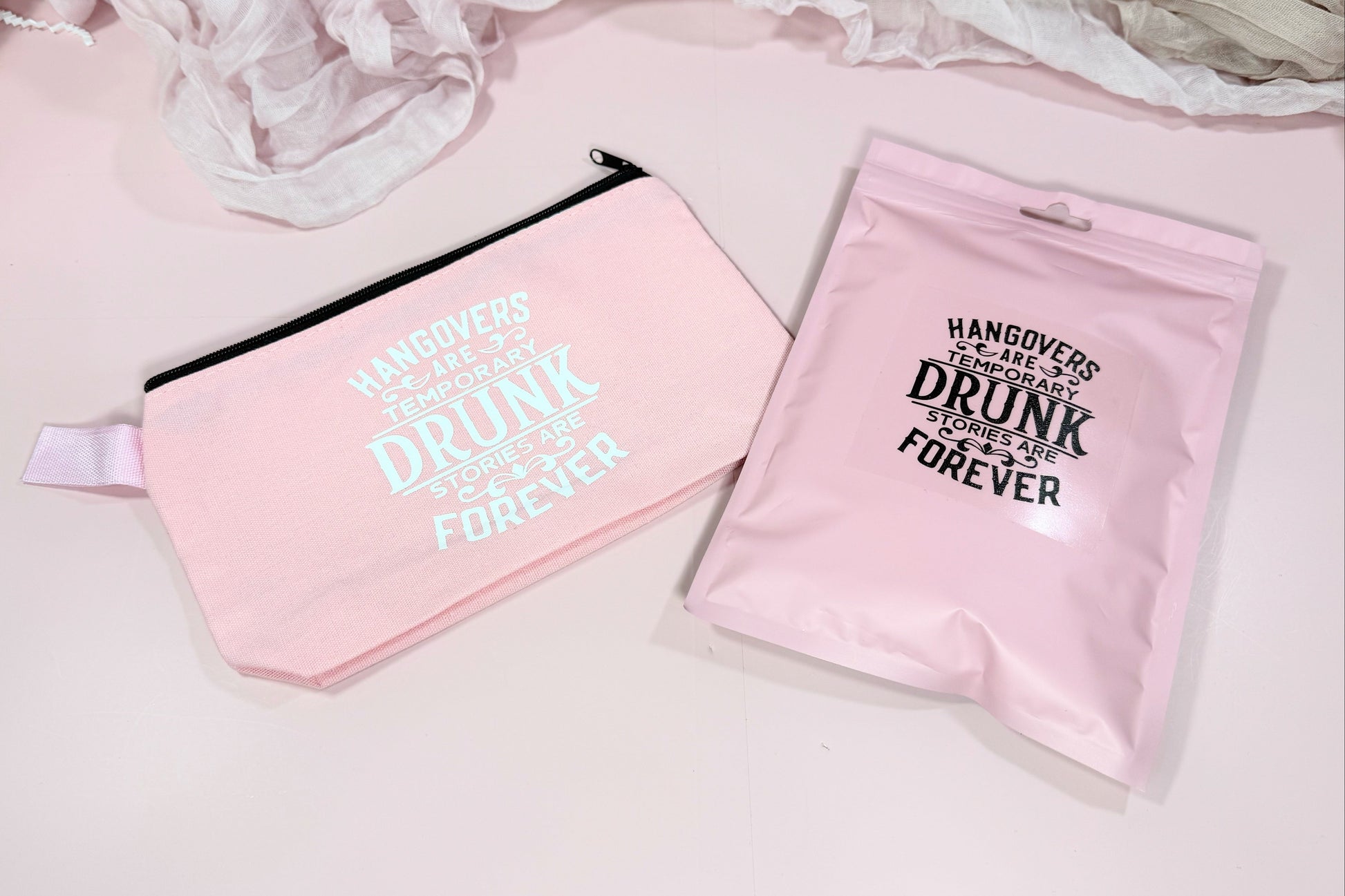 Two pink pouches with humorous text on a light background - showcasing the packaging options for NIMA Gifts Hangover Recovery Kit