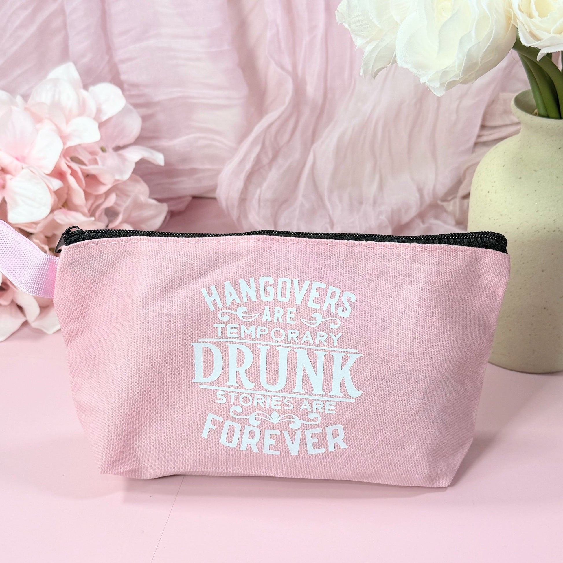 Pink pouch with humorous text on a pink background with flowers