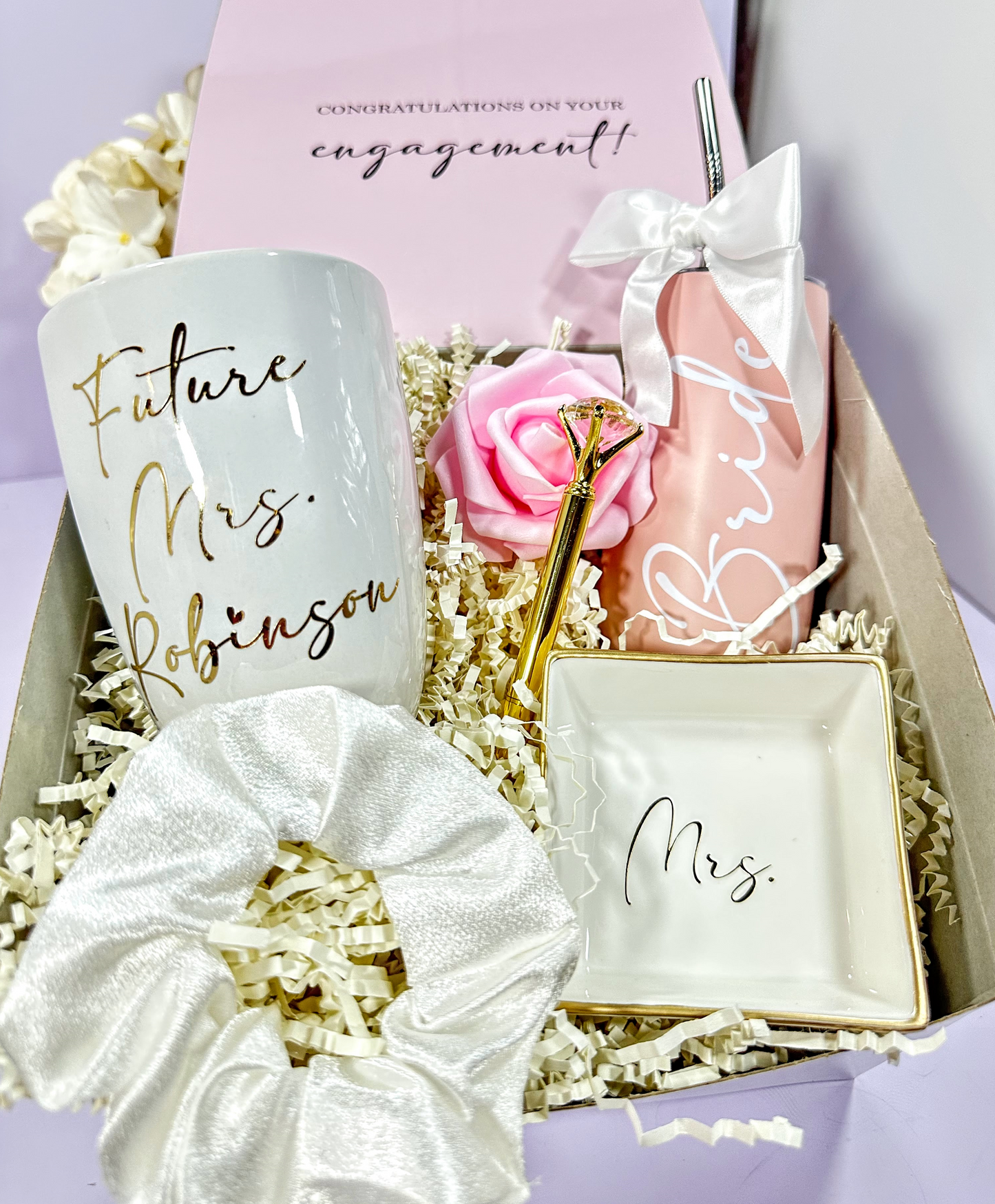 Engagement gift set with mug, scrunchie, ring box, and soap in a decorative box.