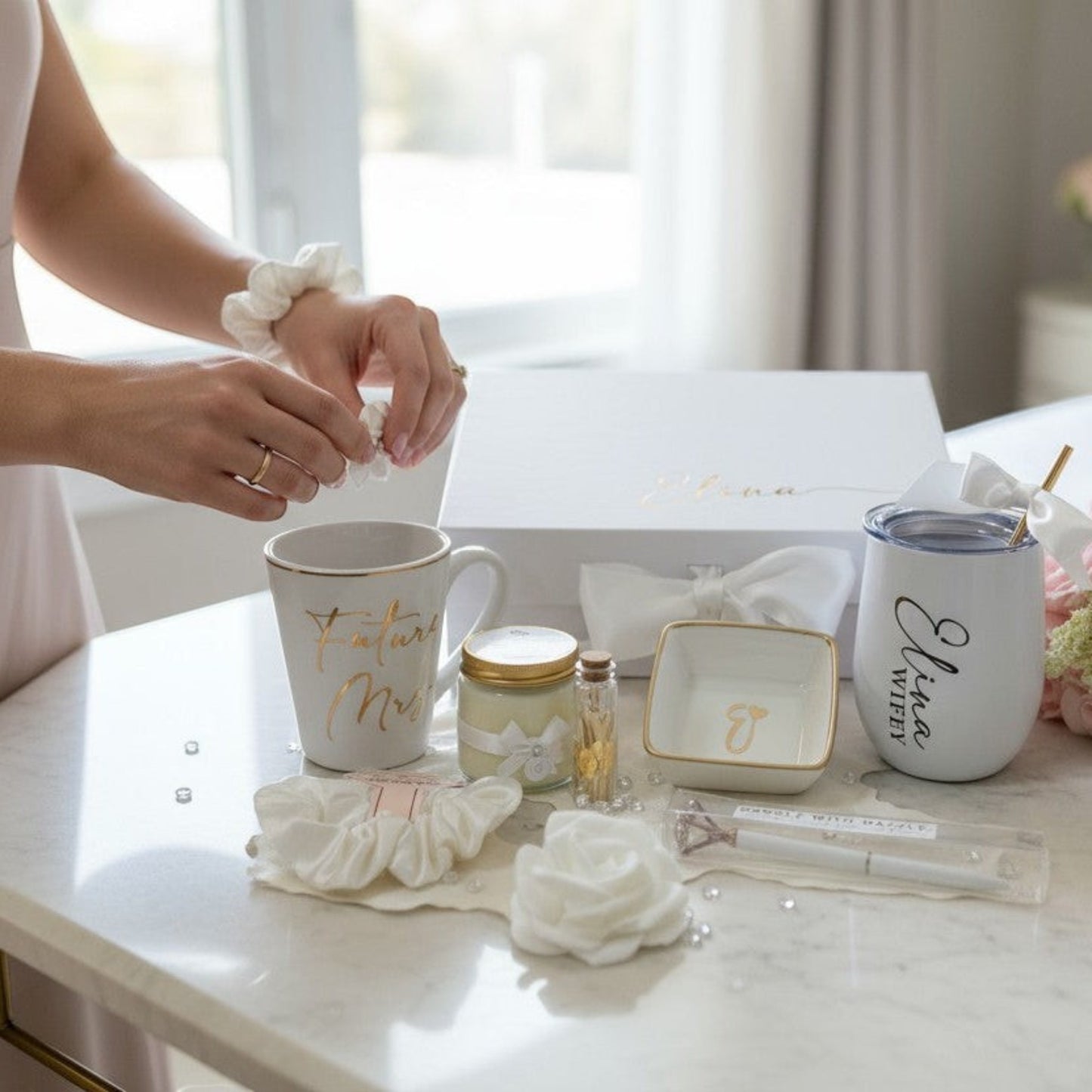 Bridal shower gift setup with mugs, jewelry, and flowers on a table.