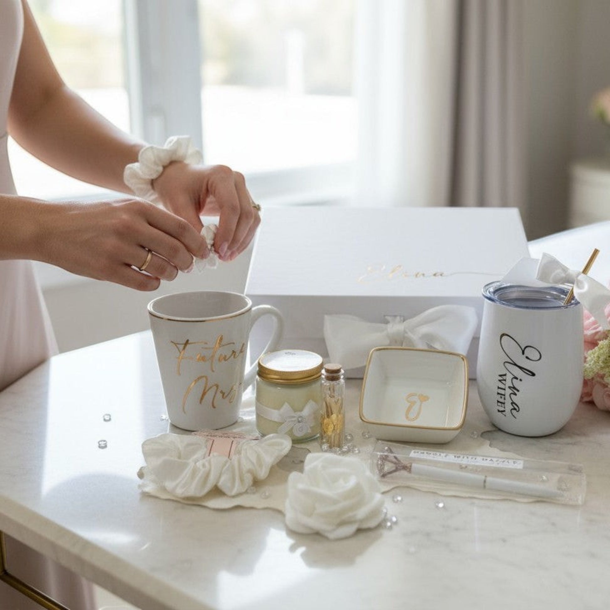 Bridal shower gift setup with mugs, jewelry, and flowers on a table.