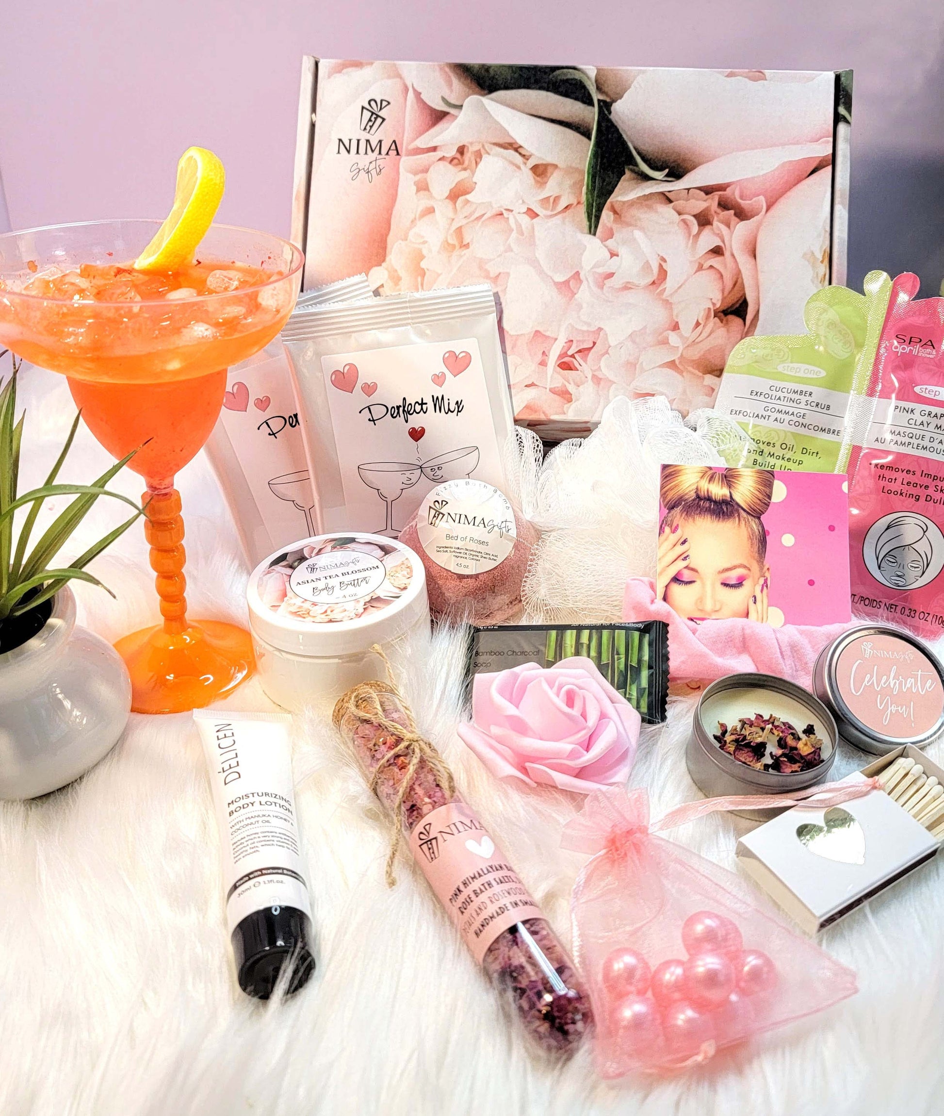 Spa items included in this peonies printed birthday gift box are various bath body products, including bath bombs, bath salts, body lotion, and a candle. The box also includes a pink rose, a glass of orange juice, and a small bag of pink beads. The text on the products reads 'NIMA Gifts', 'Perfect Mix', 'Celebrate You!' and 'Delicen Body Cream'.