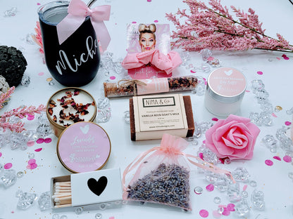 Top-down view of personalized spa birthday gift box with black wine tumbler, pink scrunchie, 4oz lavender soy candle, wooden matches, 4.25oz handmade soap, lavender sachet, pink foam rose, and 4oz body lotion arranged in custom design box.