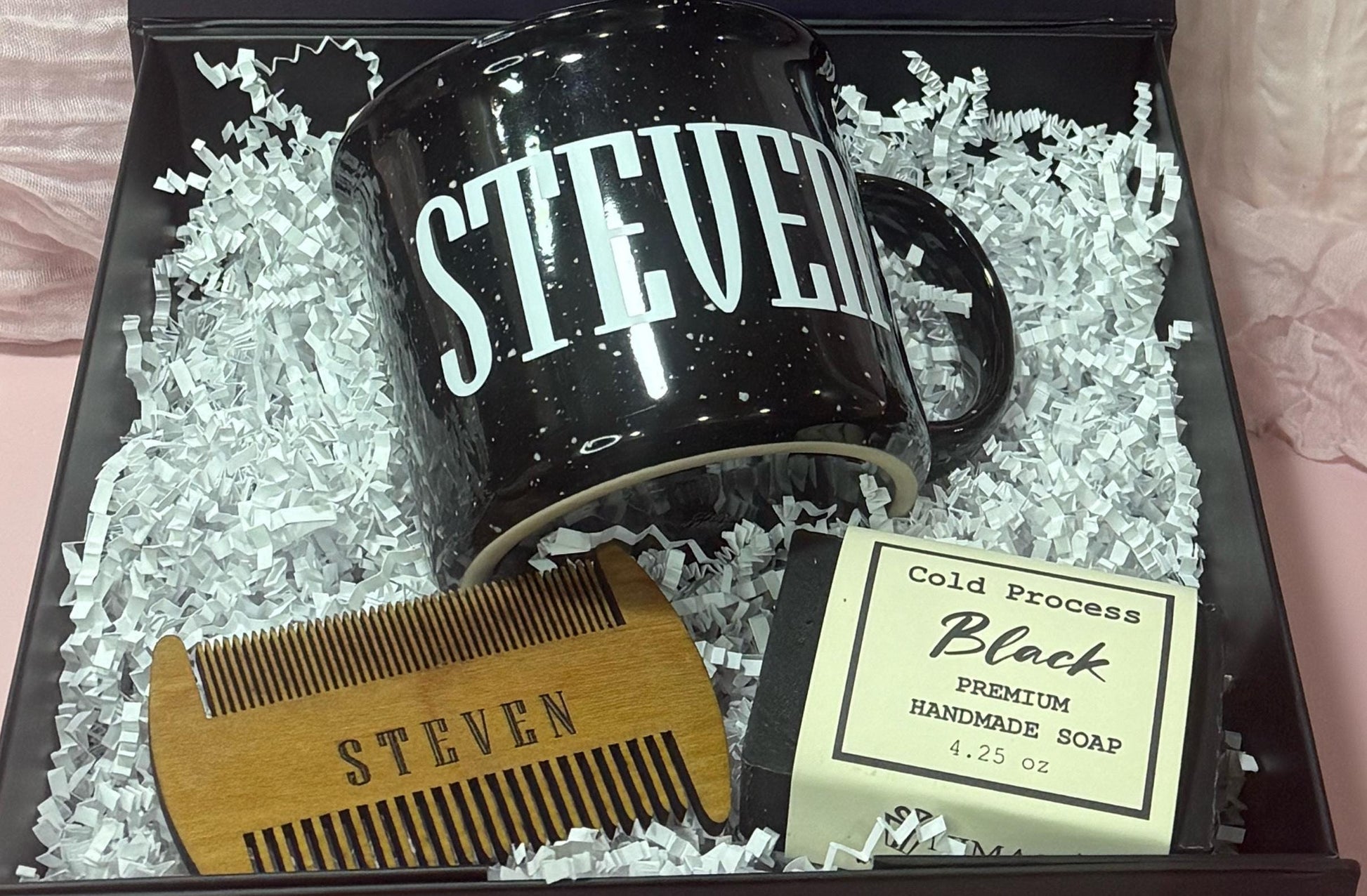 Personalized men’s gift box featuring a custom black mug with bold white “Steven,” premium handmade cold process soap, and an engraved wooden beard comb. Minimalist, modern, and ready to wow, this gift box is perfect for birthdays, Father’s Day, Christmas, anniversaries, or Valentine’s Day. A chic and stylish choice for women looking for the ultimate boyfriend gift, husband gift, or dad gift – classy packaging meets personal touch for a memorable surprise.