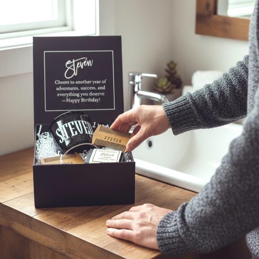 Close-up of a personalized men’s birthday gift box with engraved comb, personalized mug, black soap, beard balm, and beard oil. The black keepsake box features a birthday message inside the lid, making it the perfect blend of practical and sentimental. This stylish gift set can be personalized for birthdays, Father’s Day, anniversaries, Christmas, or Valentine’s Day. A chic and modern gift idea for women looking to surprise their boyfriend, husband, or dad with something unique and premium.