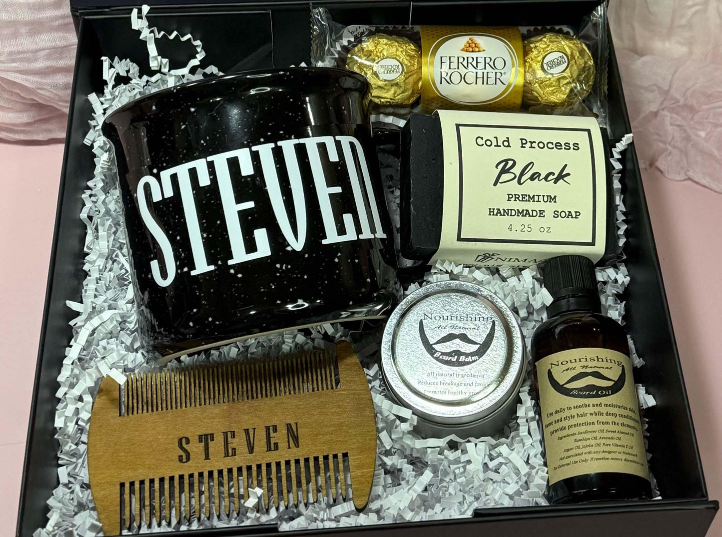 Luxury men’s birthday gift box curated to impress – includes a personalized black mug with “Steven,” engraved wooden beard comb, nourishing beard oil, beard balm, cold process handmade soap, and Ferrero Rocher chocolates. A modern and chic gift box that can be personalized and customized for any occasion: birthday, Father’s Day, Christmas, anniversary, or Valentine’s Day. Perfect for women shopping for boyfriends, husbands, or dads who deserve something stylish, thoughtful, and unforgettable.