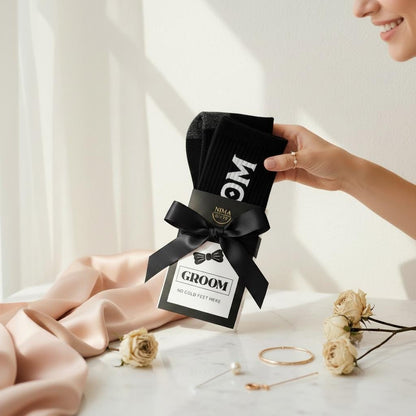 socks that are included in the bride to groom gift box with the word “Groom” on them, packaged with a black bow and have an option to have grooms initials.