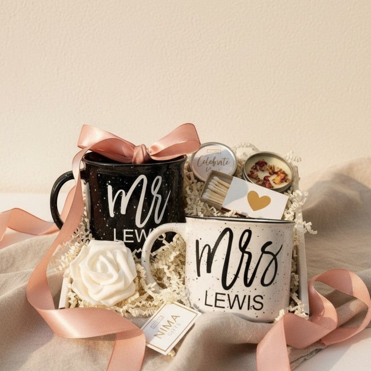 Personalized Mr. & Mrs. campfire mug engagement gift set with a black speckled mug for 'Mr.' and a white speckled mug for 'Mrs.' with couples future last names on the mugs with candle and matches.