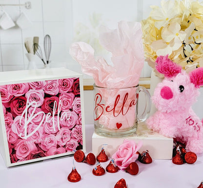 Valentines gift box for her with a cute puppy, personalized glass mug, and assorted treats for Galentines Day celebration.