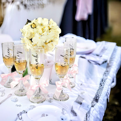 Personalized champagne flutes with "Bride Tribe" design for bachelorette party gifts, featuring elegant glassware for girls' night.